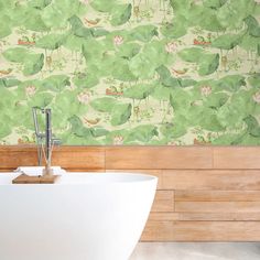 a bath tub sitting next to a wooden wall with green leaves on the wall behind it