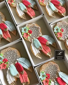 several decorated cookies in boxes with decorative designs on them, all sitting side by side