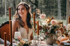 a woman sitting at a table with flowers and candles