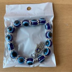 Brand New In Sealed Package Blue Evil Eye Beaded Bracelet With Hamsa Charm Blue Spiritual Bracelets With Large Beads, Blue Spiritual Stretch Bracelet With Large Beads, Blue Beaded Bracelets With Silver Beads For Beach, Spiritual Blue Stretch Bracelet With Large Beads, Blue Beaded Crystal Bracelet For The Beach, Blue Spiritual Bracelets With Letter Beads, Blue Crystal Bracelet With 8mm Beads, Blue Crystal Bracelet With Silver Beads, Spiritual Blue Bracelets With Letter Beads