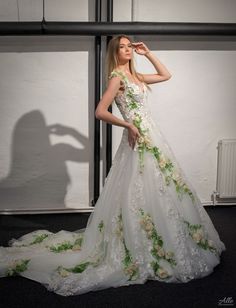 a woman in a white wedding dress standing next to a wall with her shadow on it