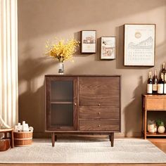 a living room with a wooden cabinet and pictures on the wall above it, in front of a window