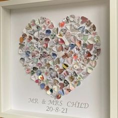 a heart made out of buttons in a white frame