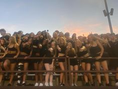 a group of cheerleaders pose for a photo on the bleachers at sunset