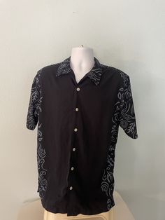 Clean from a smoke free place. Has no defects of any kind. One extra button. Length is 30 inches with a straight bottom on shirt. Machine wash cold. Casual Black Cotton Hawaiian Shirt, Casual Black Short Sleeve Shirt With Button Closure, Casual Black Shirt With Placket, Fitted Black Shirt With Camp Collar, Casual Black Camp Shirt With Button Closure, Casual Black Hawaiian Shirt With Camp Collar, Black Camp Shirt With Buttons, Cotton Camp Shirt With Buttons In Black, Black Cotton Camp Shirt With Buttons