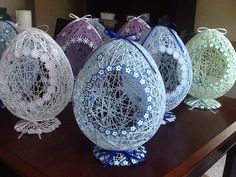 four decorative eggs sitting on top of a wooden table