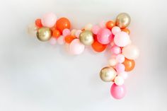 balloons are arranged in the shape of the letter f on a white background with pink, orange and gold colors