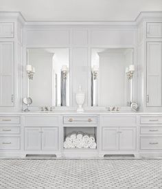 a white bathroom with two sinks and mirrors