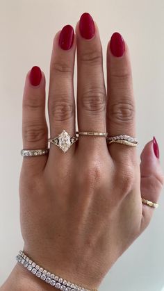 a woman's hand with three different rings on it and one ring has a diamond in the middle