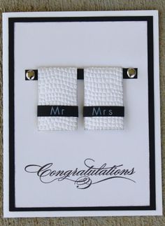 two white napkins with black ribbon are on a card that reads mr and mrs congratulations