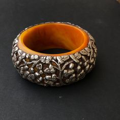 "Engraved  sterling silver Tibetan floral motif on resin statement bangle bracelet  Diameter  2.95\"   Height 1.65\"" Traditional Carved Bracelets For Formal Occasions, Handmade Bakelite Bangle Bracelet, Traditional Amber Jewelry With Carved Details, Handmade Bakelite Bracelets As Gift, Natural Tree, Resin Bracelet, Silver Bangle Bracelet, Beaded Boxes, Floral Bracelet