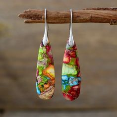 Embrace the vibrant hues of nature with our Rainbow Earth Drop Earrings. Handcrafted with meticulous care, these exquisite earrings feature a stunning array of natural stone colors, reminiscent of a serene sunset over a lush, untouched landscape. Each drop-shaped earring is a unique blend of rich reds, calming blues, earthy greens, and warm yellows, making them a perfect accessory for the free-spirited and nature-loving soul. These earrings are designed for the boho chic woman who finds joy in the beauty of the natural world and loves to express her individuality through colorful, artistic jewelry. Whether you're wandering through a peaceful forest or dancing under the stars, the Rainbow Earth Drop Earrings will complement your style and remind you of the simple, yet profound, beauty of na Earthy Greens, Treasure Jewelry, Color Flower, Jasper Stone, Free Spirited, Artistic Jewelry, Chic Woman, Finding Joy, Stone Jewelry