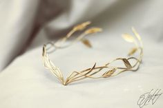 a close up of a gold bracelet with leaves on it