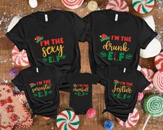 Elf Family Christmas Shirt, Personalized Elf Shirt, Christmas Matching Family Shirts, Family Christmas Pajamas, Matching Christmas Shirt   Welcome to GoldenTeeUS? We are sure that you will love our sweaters, which are different and beautiful, specially designed just for you. Now is the time to choose the most special gift for yourself and your loved ones! We wish you pleasant shopping. PRODUCT DETAILS We offer two brands for our printed shirts: Bella Canvas and Gildan SoftStyle. Both are known for their comfort and durability, but each has its unique characteristics. Please review the details below and let us know if you have a preference for either brand. Bella Canvas Unisex Sizing Fabric Weight: 4.2 oz. Materials: Solid Colors: 100% Combed and Ring-Spun Cotton Athletic Heather: 90% Combe Festive Winter Shirt With Letter Print, Black Christmas Festive Tops, Festive Black Christmas Tops, Black Festive Christmas Top, Black Festive Tops For Christmas, Festive Black Christmas Top, Christmas Festive Shirt With Graphic Print, Christmas Festive Tops With Letter Print, Festive Christmas Graphic Print Shirt