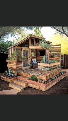 a small wooden house sitting on top of a dirt field next to trees and bushes