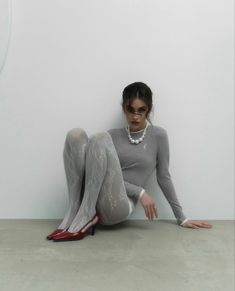 a woman sitting on the floor wearing tight stockings