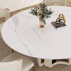 a white marble dining table with two chairs and a vase filled with flowers on top