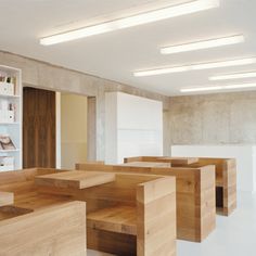 an empty room with wooden tables and white shelvings on the wall behind them