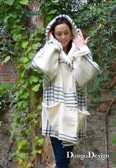 a woman is walking down the street wearing a coat and holding her hands up to her head