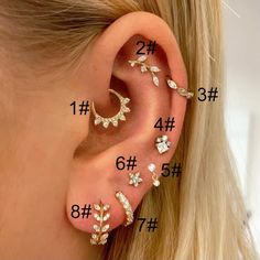 an ear with four different types of piercings on the top and bottom of it