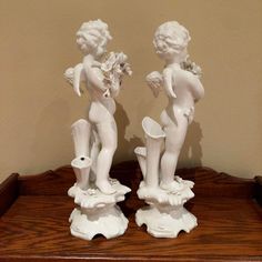 two white figurines are sitting on a table