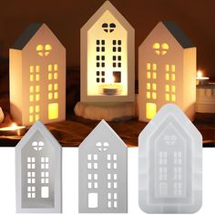 three small houses with lit candles in front of them