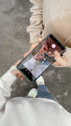 a person holding up a cell phone with an image of a man on the screen