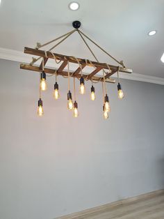 a chandelier made out of wooden planks with light bulbs hanging from it