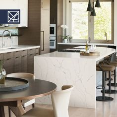 a kitchen with marble counter tops and chairs