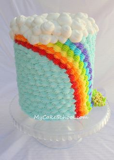 an image of a cake made to look like a rainbow colored basket with white frosting on top