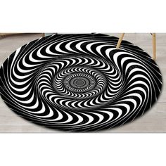 a black and white circular rug with an abstract design on the floor in front of a chair