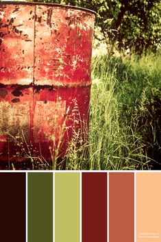 a red barrel sitting in the middle of some tall grass