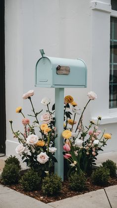 a blue mailbox with flowers growing out of it