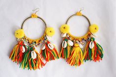 These are the most amazing big boho beaded brass hoop tassel Rasta statement earrings. These large bohemian fringe earrings are handmade and one-of-a-kind. Made with big gold brass hoops, colorful beads, brass bells, and 100% cotton yarn with natural cowry shells. The brass hoops measure approximately 6 cm in diameter. There are big yellow cotton pom pom's and red, gold, and green tassels dangling with little bras bells that make the loveliest little jingle sound! These  earrings measure approxi Rasta Earrings, Green Statement Earrings, Pom Earrings, Cowry Shell, Pom Pom Earrings, Western Purses, Bead Bangles, Boho Leather, Statement Ring Silver