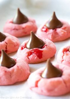 some pink cookies with chocolate on top