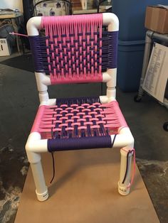 a pink and purple chair sitting on top of a wooden table