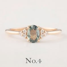 an oval cut green and white diamond ring with three diamonds on the band, set in yellow gold