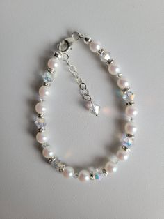 "This white bracelet is made with White Pearlescent Czech Crystal Pearls, Clear AB Czech crystal bicones and silver-plated clear crystal rondelles. The Swarovski pearls have a beautiful luster finish. The Czech crystal adds even more shimmer to this lovely bracelet. The lobster claw clasp and 1\" beaded extention are sterling silver. Custom Orders are always welcome! Ask about free sizing." White Pearl Bracelet With Spacer Beads, Elegant White Crystal Bracelet With Spacer Beads, White Beaded Crystal Bracelets, White Beaded Bracelet For Anniversary, White Crystal Bracelet With Silver Beads, White Pearl Bracelet With Spacer Beads For Wedding, Handmade White Crystal Bracelet, White Beaded Crystal Pearl Bracelet, White Crystal Bracelet With Round Beads