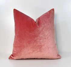 a pink velvet pillow on a white background with the back turned to look like it has been dyed