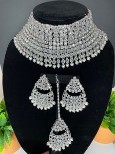 This elegant and gorgeous choker with matching earrings and tikka is sure to be a hit for any event! The neutral colors can match any outfit and the colors are perfect for any summer occasion! It comes in 2 beautiful tones with a pastel pink and copper and a silver finish look as well. It hugs the neck and is made of high quality stones. Sabyasachi Bridal Jewellery Set, Cheap Silver Kundan Necklace Gift, Festive Kundan Silver Sets, Traditional Silver Sets For Reception, Silver Chandbali Lehenga With Stone Work, Silver Kundan Lehenga For Festive Occasions, Traditional Silver Hand Set, Silver Traditional Sets For Reception, Silver Sets With Intricate Design For Reception