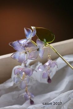 a close up of a flower on a stick with water droplets hanging from it's stems