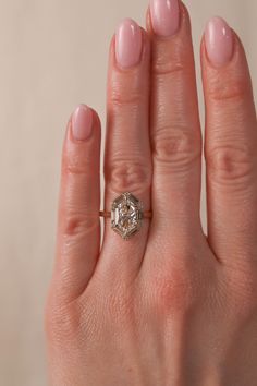 a woman's hand with a ring on it and a diamond in the middle