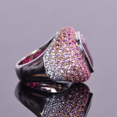 A gorgeous 12.21 carat trillion cut rubellite that is surrounded by an ombre of diamonds and pink sapphires. Made of 5.65 carats of delicate pink sapphires and .62 carats of white diamonds, all are set in 18k gold. This statement ring is very unique and a real eye catcher. Ring size is a 7 and weighs 25.8 grams. Luxury Pink Sapphire Ring With Pave Setting, Luxury Pink Rings With Pave Setting, Formal Pink Sapphire Ring With Pave Setting, Luxury Pink Ruby Ring With Diamond, Luxury Pink Ruby Diamond Ring, Luxury Pink Ruby Ring For Formal Occasions, Luxury Pink Multi-stone Sapphire Ring, Luxury Pink Diamond Ring With Pink Sapphire, Luxury Pink Multi-stone Ruby Ring