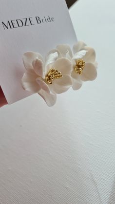 a pair of white flowers on top of a piece of paper that says medze bride