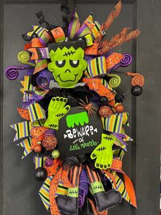 a halloween wreath that has been decorated with green and orange decorations