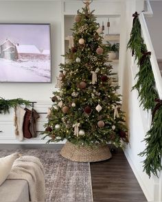 a decorated christmas tree sitting in the corner of a living room next to a staircase