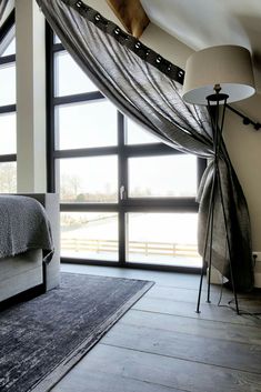 a bedroom with large windows and a gray rug