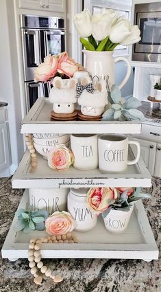 three tiered trays holding coffee mugs and flowers