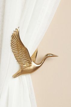 a gold bird is hanging on the curtain