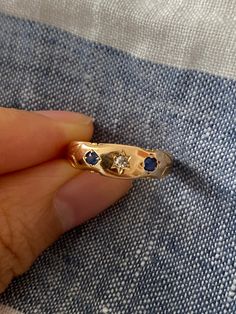 Antique Victorian era 15ct (aka 15K) Gold Ring with Sapphires and Diamond. White diamond (Approx 0.10ct) star set to the front center with blue sapphire on either side. A smooth band.  One of the sapphires appears to be a replacement and is slightly larger than the original. Overall condition is good with some light surface wear and scratches commensurate with age, nice strong band, one sapphire stone shows surface abrasions. Total weight: 1.95g. Size: 5 Fully hallmarked for 15ct gold, Birmingha Heirloom Sapphire Ring With Diamond, Celestial Style Sapphire Ring With Diamond For Anniversary, Celestial Sapphire Ring With Diamond For Anniversary, Celestial Sapphire Birthstone Ring For Anniversary, Celestial Sapphire Anniversary Ring With Birthstone, Heirloom 14k Gold Sapphire Ring With Single Cut Diamonds, 14k Gold Sapphire Diamond Cut Ring, Timeless Sapphire Diamond Ring Birthstone, Timeless Diamond Sapphire Birthstone Ring